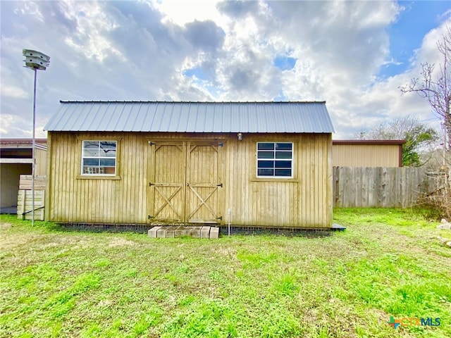 view of outbuilding featuring an outbuilding and fence