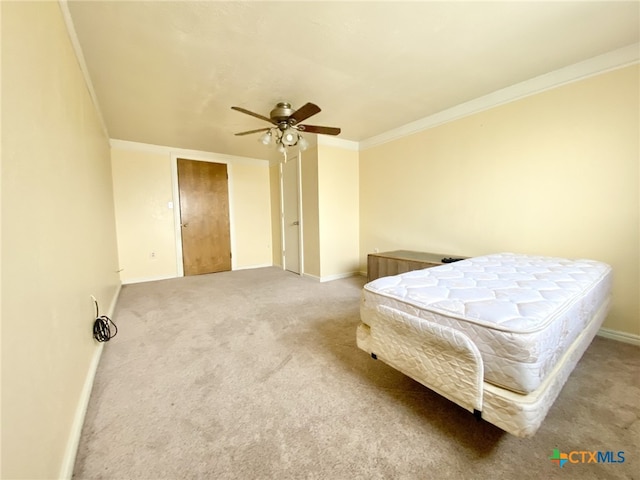 carpeted bedroom featuring baseboards, a ceiling fan, and crown molding