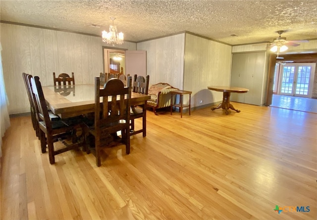 dining room with light wood finished floors, ornamental molding, and a chandelier