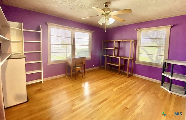 miscellaneous room featuring a ceiling fan, a textured ceiling, baseboards, and wood finished floors