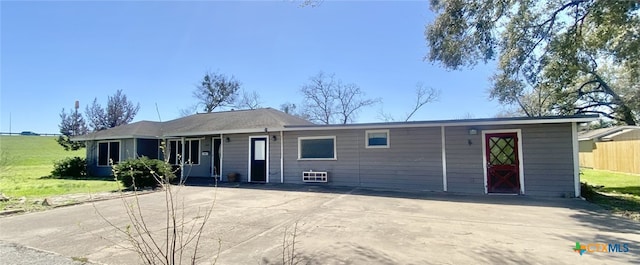 ranch-style home with concrete driveway and fence