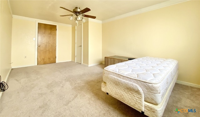 bedroom featuring baseboards, carpet flooring, a ceiling fan, and crown molding