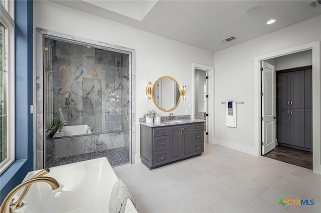 bathroom with tiled shower and vanity