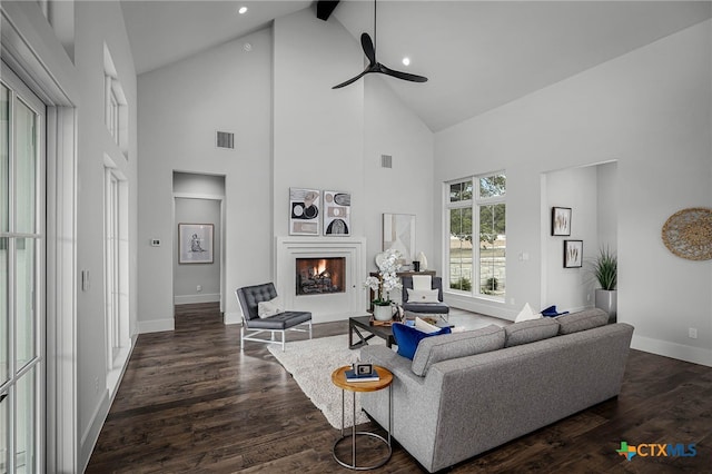 living room featuring beam ceiling, dark wood-type flooring, high vaulted ceiling, and ceiling fan