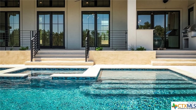 view of pool with a hot tub and french doors