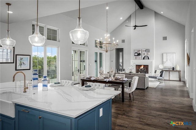 kitchen featuring pendant lighting, blue cabinets, beamed ceiling, sink, and dark hardwood / wood-style flooring