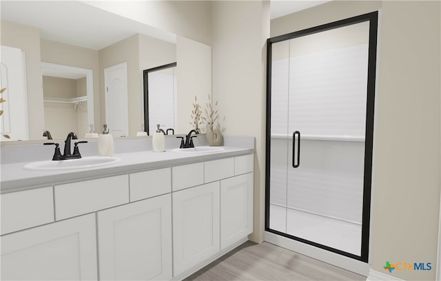 bathroom with hardwood / wood-style floors, vanity, and a shower with shower door