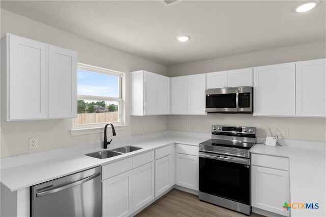 3816 Poteet Ct, Temple, TX 76504 - kitchen with appliances with stainless steel finishes, recessed lighting, white cabinets, light countertops, and light wood-style flooring