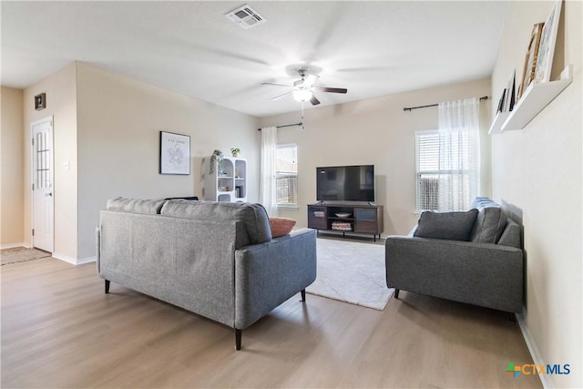 living room featuring ceiling fan, light hardwood / wood-style floors, and plenty of natural light