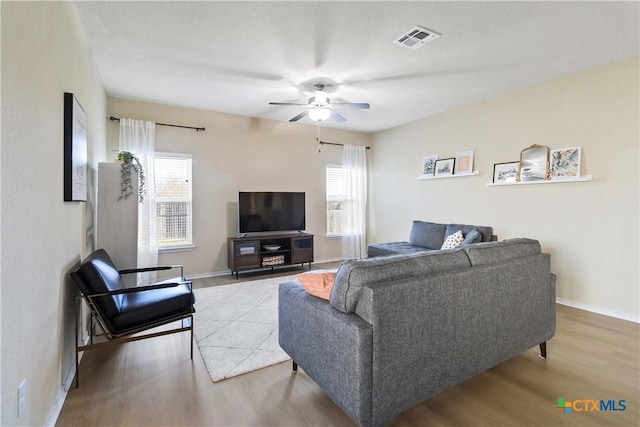 living room with light hardwood / wood-style flooring, a wealth of natural light, and ceiling fan