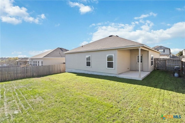 back of property with a yard and a patio