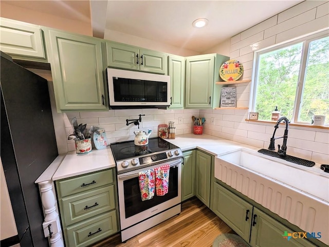 127 Forest Mist, Canyon Lake, TX 78133 - kitchen featuring electric stove, green cabinets, tasteful backsplash, and light countertops