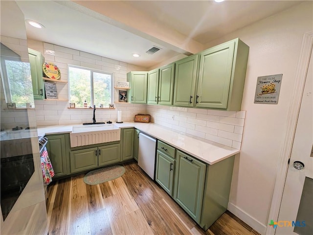 127 Forest Mist, Canyon Lake, TX 78133 - kitchen with green cabinetry, decorative backsplash, visible vents, dishwasher, and light wood finished floors