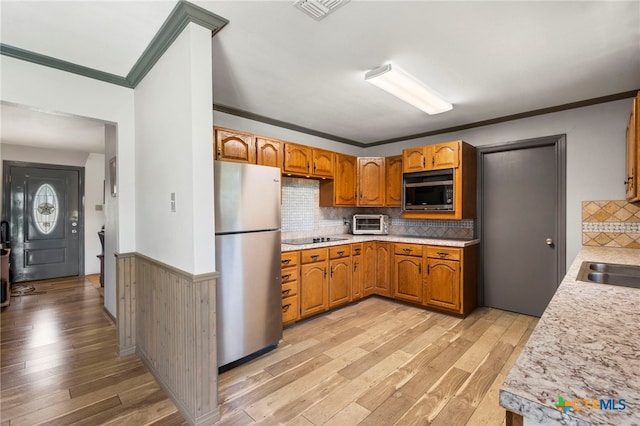 801 Billie Brooks Ln, Driftwood, TX 78619 - kitchen featuring freestanding refrigerator, ornamental molding, light wood-style flooring, light countertops, and wainscoting