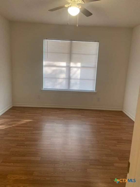 unfurnished room featuring ceiling fan and dark wood-type flooring