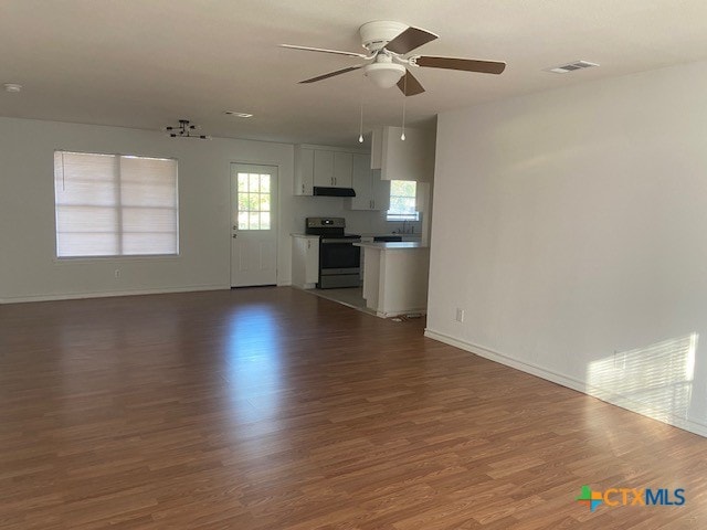 unfurnished living room featuring ceiling fan and wood-type flooring