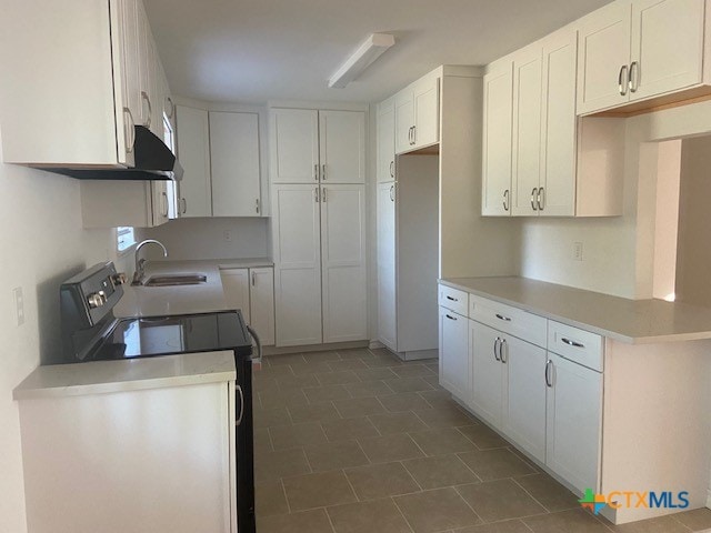 kitchen with electric stove, white cabinetry, sink, and ventilation hood