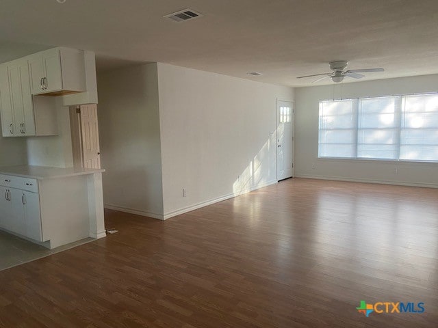 unfurnished living room featuring hardwood / wood-style flooring and ceiling fan