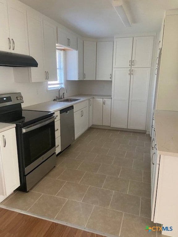 1025 E Fannin St, Luling, TX 78648 - kitchen featuring stainless steel appliances, under cabinet range hood, white cabinetry, and light countertops