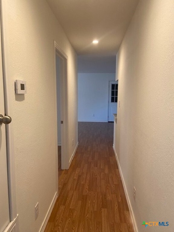 corridor featuring dark wood-type flooring