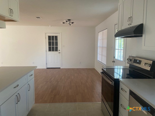 1025 E Fannin St, Luling, TX 78648 - kitchen with appliances with stainless steel finishes, under cabinet range hood, dark wood-style floors, and light countertops