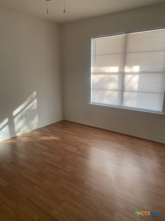 empty room featuring ceiling fan and dark wood-type flooring