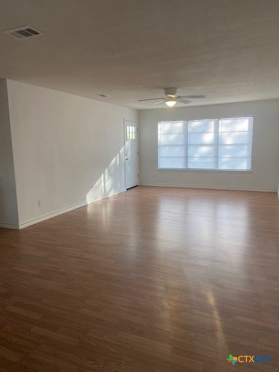 empty room featuring ceiling fan and dark hardwood / wood-style flooring