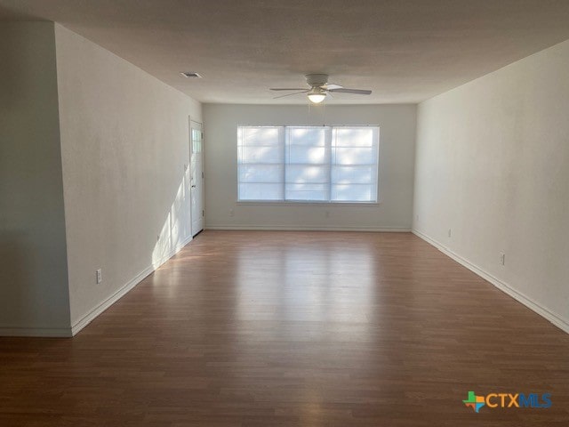 unfurnished room featuring dark hardwood / wood-style floors and ceiling fan