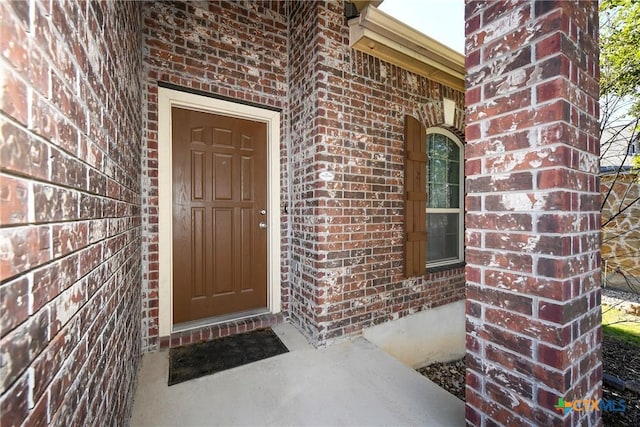 entrance to property featuring brick siding