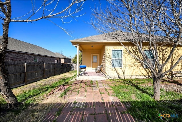back of property featuring a patio and fence