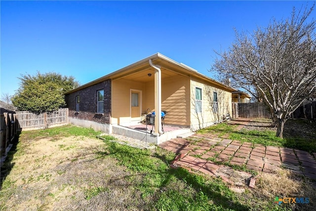 back of property with a patio and a fenced backyard