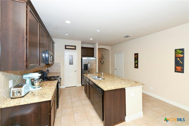 kitchen featuring black appliances, a sink, light tile patterned floors, dark brown cabinets, and recessed lighting
