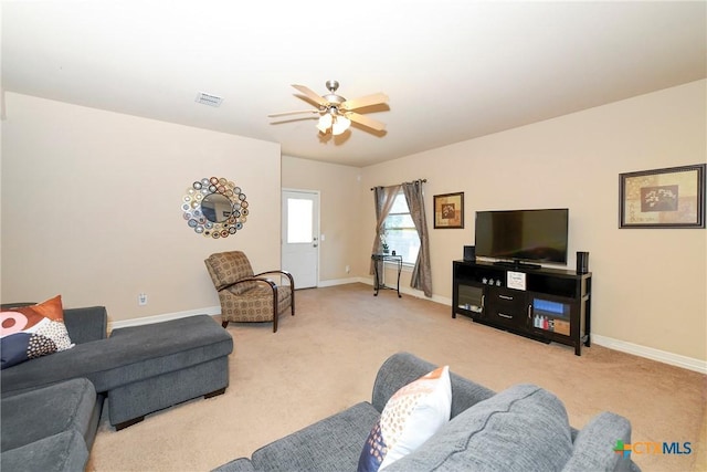 carpeted living room featuring ceiling fan and baseboards
