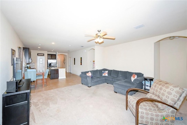 living area with arched walkways, ceiling fan, light colored carpet, and recessed lighting