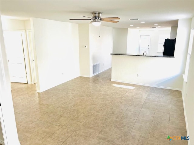 tiled spare room with ceiling fan