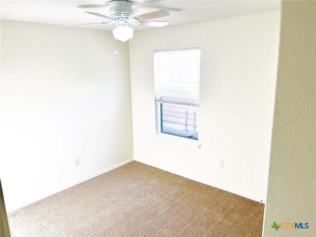 spare room with ceiling fan and carpet