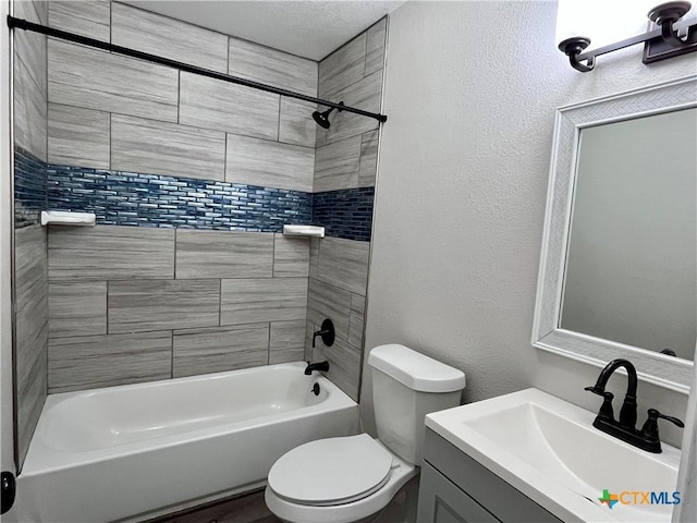 full bathroom with toilet, vanity, and tiled shower / bath