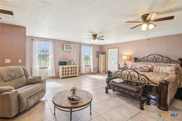 103 Misty Bnd, Floresville, TX 78114 - bedroom with a ceiling fan, light tile patterned flooring, a textured ceiling, and an AC wall unit