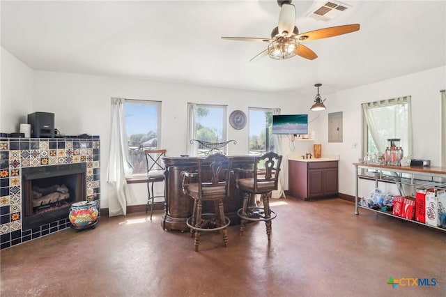 103 Misty Bnd, Floresville, TX 78114 - dining room featuring a tile fireplace, visible vents, concrete flooring, baseboards, and ceiling fan