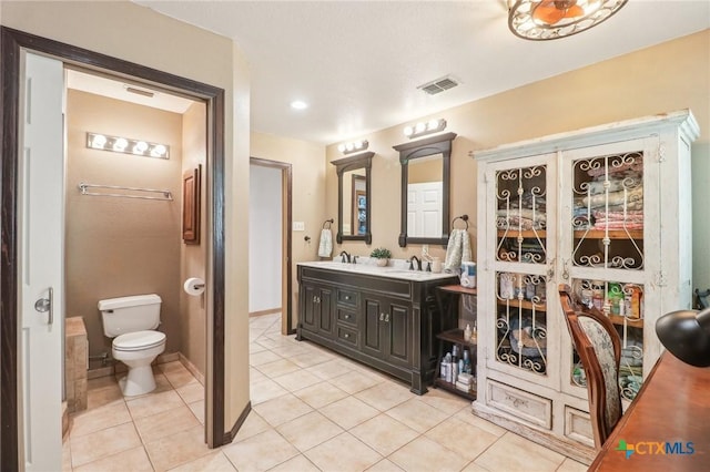 103 Misty Bnd, Floresville, TX 78114 - bathroom featuring double vanity, toilet, a sink, visible vents, and tile patterned flooring
