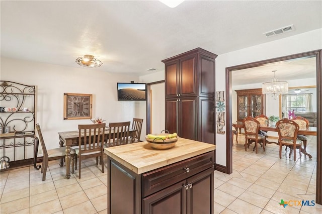 103 Misty Bnd, Floresville, TX 78114 - kitchen featuring pendant lighting, light tile patterned floors, wooden counters, visible vents, and a chandelier