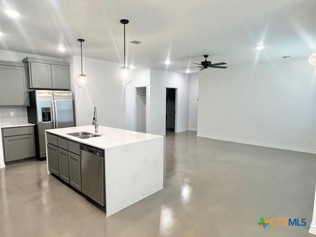 kitchen featuring finished concrete flooring, appliances with stainless steel finishes, gray cabinets, and a sink