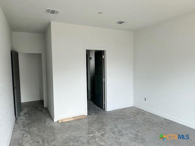 unfurnished bedroom featuring unfinished concrete flooring and visible vents