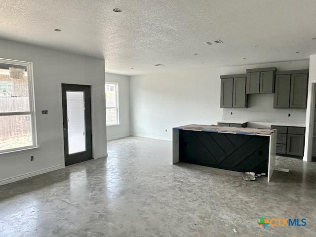 kitchen featuring visible vents, concrete floors, a textured ceiling, and baseboards