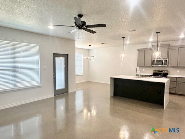kitchen with a sink, a textured ceiling, visible vents, gray cabinets, and appliances with stainless steel finishes