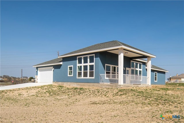 back of house with concrete driveway, an attached garage, and stucco siding