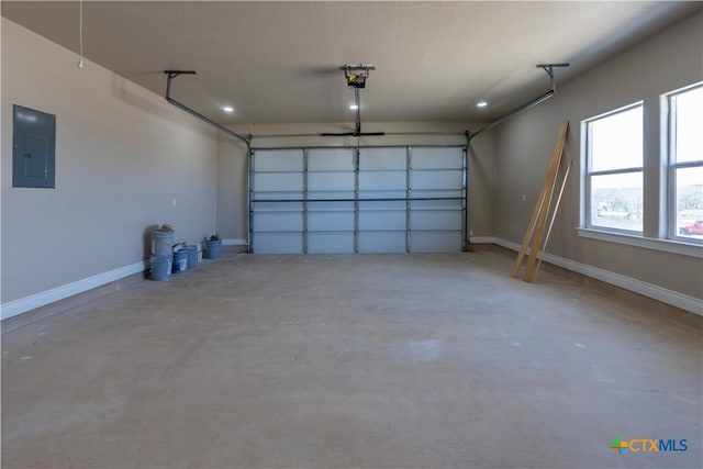 garage featuring electric panel, a garage door opener, and baseboards