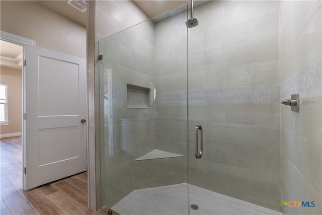 full bath with a stall shower, visible vents, and wood finished floors