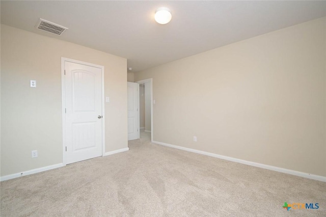 unfurnished room featuring light carpet