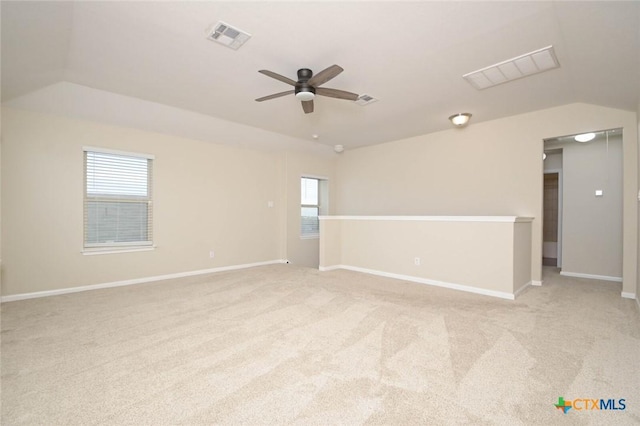 carpeted spare room featuring lofted ceiling and ceiling fan